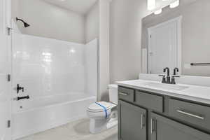 Full bathroom with  shower combination, vanity, toilet, and marble finish floors