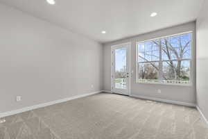 Carpeted empty room with plenty of natural light, baseboards, and recessed lighting