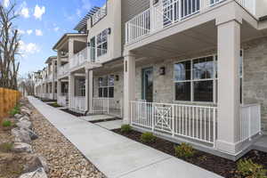 View of exterior entry featuring a porch and stone siding