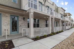 Property entrance featuring covered porch and stone siding