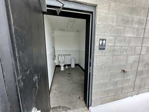 Bathroom featuring concrete flooring and toilet