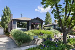 View of front facade with a chimney, concrete driveway, and brick siding