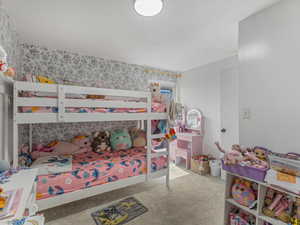 Bedroom featuring wallpapered walls and carpet