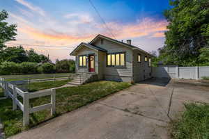 Bungalow-style home featuring concrete driveway and a chimney