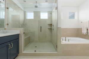 Bathroom featuring vanity, a shower stall, and a garden tub
