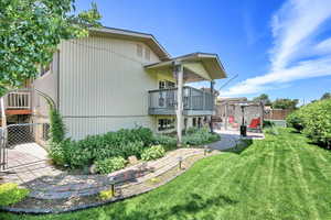Rear view of house with a balcony and a patio area