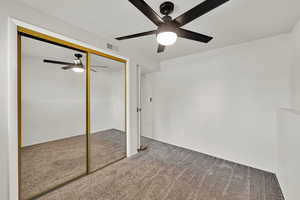 Unfurnished bedroom featuring carpet flooring, a closet, and ceiling fan