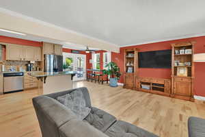 Living room with light wood-style flooring, ornamental molding, french doors, and a ceiling fan