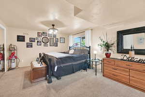 Carpeted bedroom with a textured ceiling and baseboards