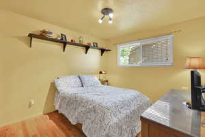 Bedroom with wood finished floors and baseboards