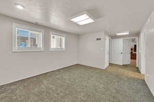 Carpeted empty room featuring a textured ceiling