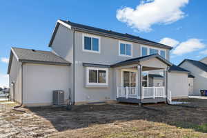 Back of property featuring a wooden deck and stucco siding