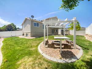 Rear view of house with a pergola, a fire pit, and a gate