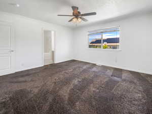 Unfurnished room featuring carpet flooring, ceiling fan, a textured ceiling, baseboards, and crown molding