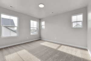 Spare room featuring carpet floors and baseboards
