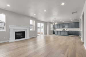 Kitchen featuring stainless steel appliances, light countertops, open floor plan, a chandelier, and baseboards