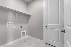 Laundry room with hookup for an electric dryer, baseboards, light marble finish floors, and washer hookup