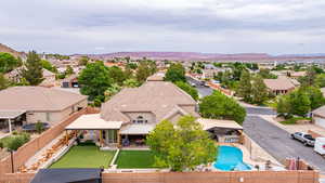 Aerial view of residential area featuring a mountainous background and a pool area