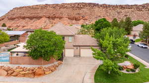 View of front facade featuring a tiled roof, driveway, stucco siding, a mountain view, and an attached garage