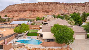 View of swimming pool featuring a fenced backyard, a mountain view, a pool with connected hot tub, and a patio