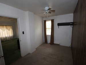 Spare room featuring a ceiling fan, carpet, baseboard heating, and baseboards