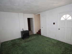 Entrance foyer with stairway, heating unit, and carpet floors