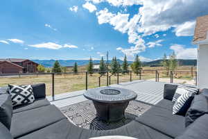 View of patio / terrace with an outdoor living space with a fire pit, a mountain view, and a view of rural / pastoral area