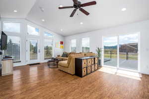 Living room featuring lofted ceiling, wood finished floors, healthy amount of natural light, ceiling fan, and recessed lighting
