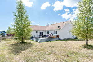 Back of property with a wooden deck and stucco siding
