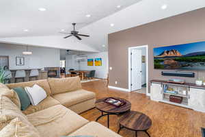 Living area featuring wood finished floors, lofted ceiling, ceiling fan, recessed lighting, and baseboards
