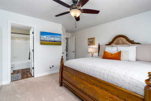 Bedroom featuring light colored carpet, baseboards, connected bathroom, and a ceiling fan