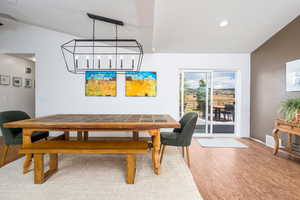 Dining room featuring wood finished floors, baseboards, vaulted ceiling, and recessed lighting