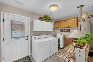 Laundry room with independent washer and dryer, cabinet space, and water heater
