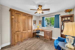 Office featuring baseboards, light wood finished floors, and a ceiling fan