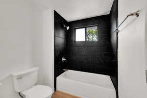 Full bath featuring toilet and bathing tub / shower combination
