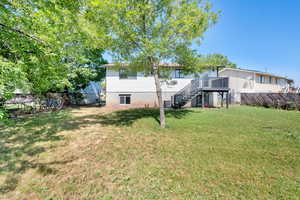 Back of house featuring stairway, a fenced backyard, and a deck