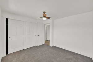 Unfurnished bedroom with carpet flooring, a closet, and a ceiling fan