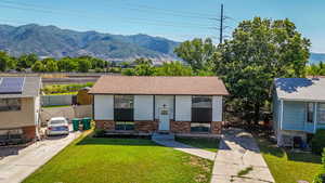 Split foyer home featuring brick siding, driveway, a mountain view, and entry steps