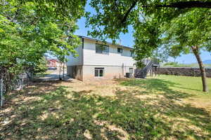Rear view of property with stairway, a fenced backyard, and a gate
