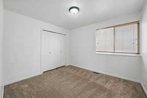 Unfurnished bedroom featuring carpet, baseboards, and a closet