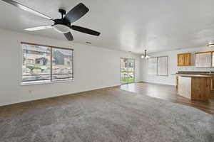 Unfurnished living room with dark carpet, a chandelier, and baseboards