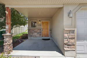 Entrance to property featuring stone siding and stucco siding