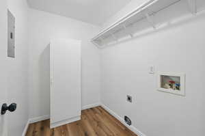 Washroom featuring washer hookup, hookup for an electric dryer, wood finished floors, and baseboards