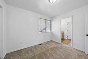 Spare room featuring carpet flooring and baseboards