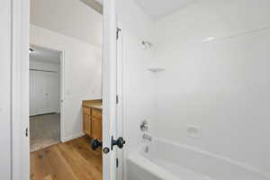 Full bath with wood finished floors, tub / shower combination, and vanity