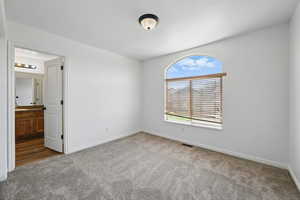 Spare room featuring carpet and baseboards