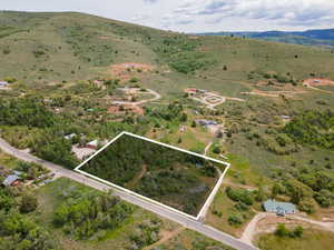 Aerial view of sparsely populated area with a mountain backdrop and property parcel outlined