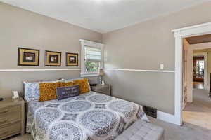 Bedroom with carpet, multiple windows, and baseboards