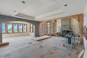 Living area featuring a tray ceiling and arched walkways