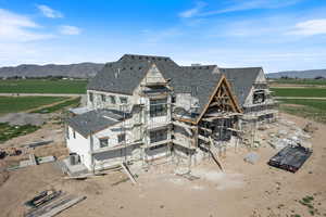 Rear view of property with a mountain view, central AC, a view of countryside, and roof with shingles